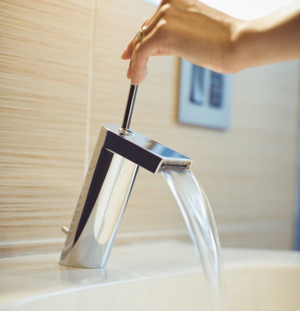 detail of a modern faucet with female hand